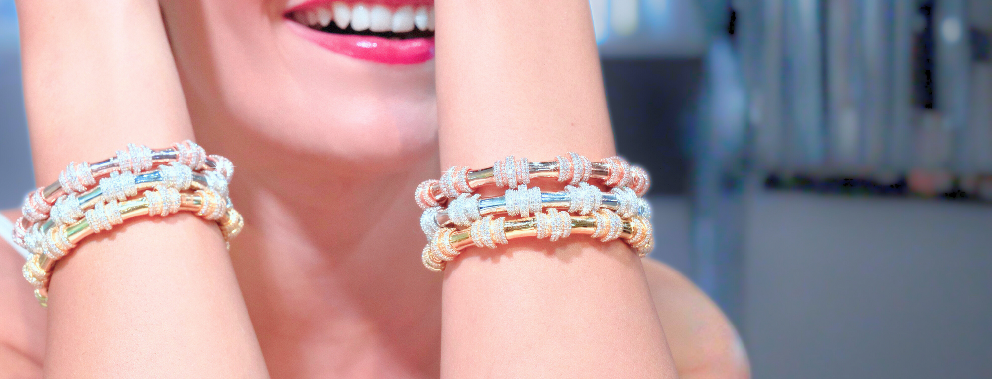Close-up of a woman's hand wearing multiple bracelets with a blurred background